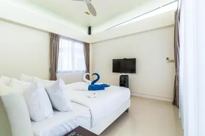 a hotel room with a white bed and a tv at Phuket villa in Laguna Park in Bang Tao Beach