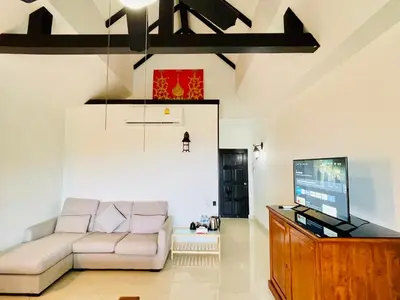 a living room with a couch and a tv at Boomerang Village Resort Kata in Kata Beach