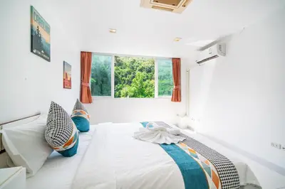 a white bedroom with a bed with a window at patong villa2：四卧泳池别墅/两个海景房/近班赞酒吧街 in Patong Beach