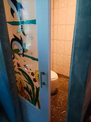 a bathroom door with a window with a painting of a toothbrush at Malai Maikhao Near Beach in Ban Mai Salae