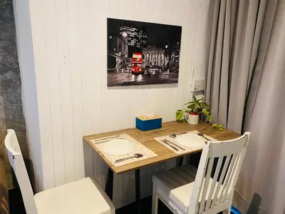 a small table with two chairs and a wooden table with at Malai Maikhao Near Beach in Ban Mai Salae