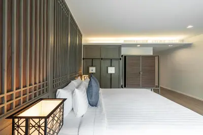a bedroom with a large bed with white pillows at Bella Nara Phuket Naiyang Beach in Nai Yang Beach