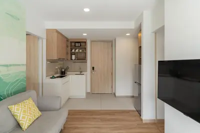 a living room with a couch and a kitchen at 2 br Terrace Laguna, SkyPark in Thalang