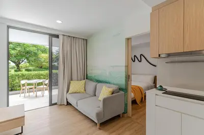 a living room with a couch and a bedroom at 2 br Terrace Laguna, SkyPark in Thalang