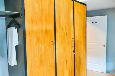 a wooden cabinet in a room with a door at Bell Lifestyle Hostel Phuket in Nai Yang Beach