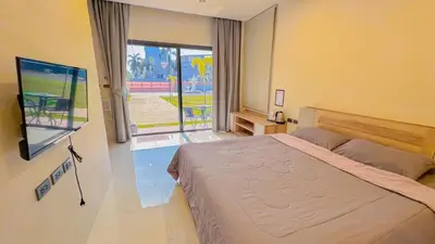 a bedroom with a large bed and a large window at The Memories Hill Phuket in Thalang