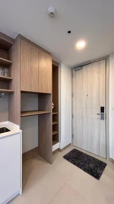a kitchen with wooden cabinets and a sliding door at 1 Bedroom Sky Park corner in Bang Tao Beach