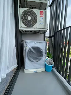 a fan sitting on a balcony next to a window at 1 Bedroom Sky Park corner in Bang Tao Beach