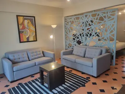 a living room with two couches and a table at New Breakers Hotel Rawai in Rawai Beach