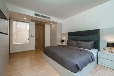 a bedroom with a large bed with a black headboard at Baan Mai Khao apartments Phuket in Mai Khao Beach