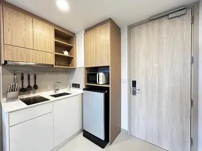a kitchen with white cabinets and a black refrigerator at 1 Bdr Sky Park Golf view in Bang Tao Beach