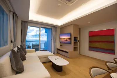 a living room with a white couch and a tv at Chic Design & Full Seaview 2BR Karon Condo 16C, near Beach in Karon Beach