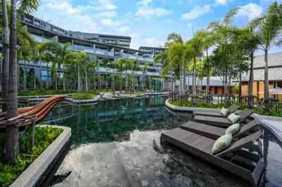 a resort with a pool with palm trees and a building at Deluxe apartment with sea view and jacuzzi in Surin Beach