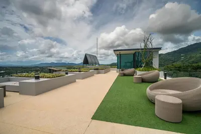 a building with benches and grass on a roof at Deluxe apartment with sea view and jacuzzi in Surin Beach