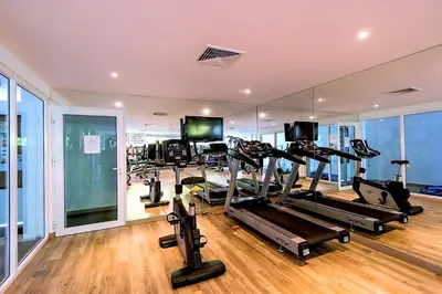 a gym with treadmills and ellipticals and a mirror at Spacious apartment at Kata Ocean View M11 in Kata Beach