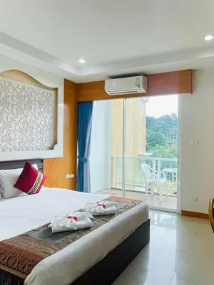 a bedroom with a large bed and a balcony at T & C Hotel Patong Beach in Patong Beach