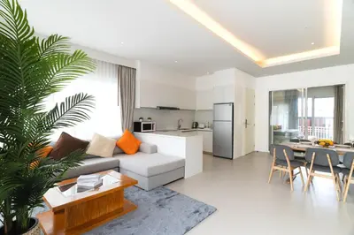 a living room with a couch and a table and a kitchen at Kamala Garden View Villa 3 Bdr in Kamala Beach