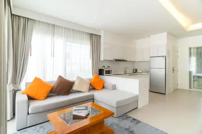 a living room with a couch and a kitchen at Kamala Garden View Villa 3 Bdr in Kamala Beach