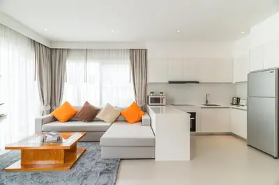 a living room with a couch and a kitchen at Kamala Garden View Villa 3 Bdr in Kamala Beach