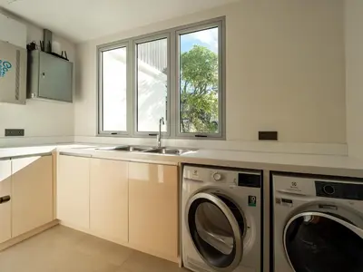 a kitchen with a sink and a washing machine at ANGSANA Beachfront Residences apartment with pool in Laguna Phuket in Bang Tao Beach