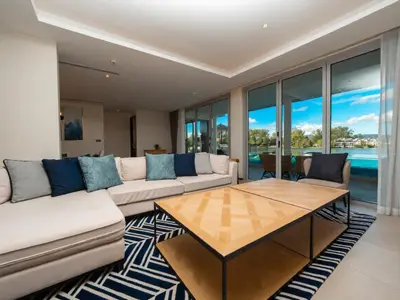 a living room with a couch and a table at ANGSANA Beachfront Residences apartment with pool in Laguna Phuket in Bang Tao Beach