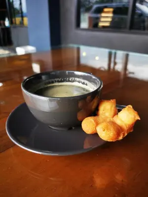 a bowl of soup on a plate with some food at Pinpoint Hotel Phuket in Ban Pak Lak