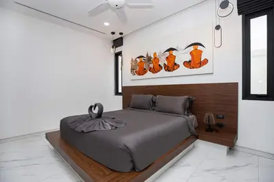 a bedroom with a bed and a painting of cats at Villa Brianna Luxuria 4 - Rawai in Rawai Beach