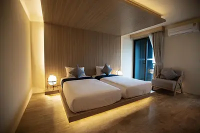 a bedroom with a large bed and a window at The Arch Phuket Hotel in Ban Ket Ho