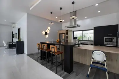 a kitchen with a large island with bar stools at Villa Brianna Luxuria 2 - Rawai in Phuket Town