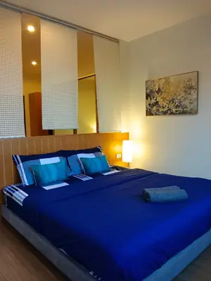 a large blue bed with blue pillows in a bedroom at Hill Myna Condotel by Bcare - One Bedroom in Ban Thalat Choeng Thale