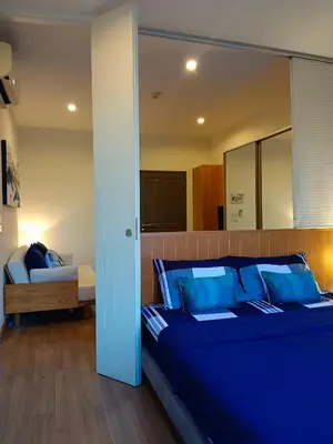 a bedroom with a bed with blue pillows at Hill Myna Condotel by Bcare - One Bedroom in Ban Thalat Choeng Thale