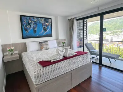 a bedroom with a bed with two towels on it at Bliss Patong - 2Br Sea View Condo - Roof Top Pool in Patong Beach