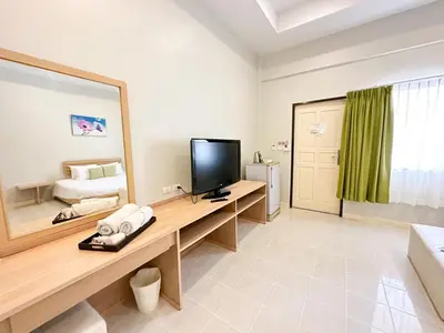 a room with a desk with a television and a bedroom at Favorite Place in Kata Beach