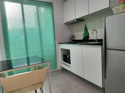 a kitchen with white cabinets and a window with green blinds at 5 Floor - The Base Downtown Condominium next to Central Shopping Mall in Phuket Town