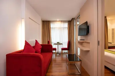 a living room with a red couch and a tv at iCheck inn Residences Patong in Patong Beach