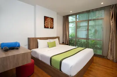 a bedroom with a bed and a large window at iCheck inn Residences Patong in Patong Beach