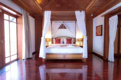 a bedroom with a white bed with red pillows at Classic Thai style Cozy Villa fancy pool+garden in Patong Beach