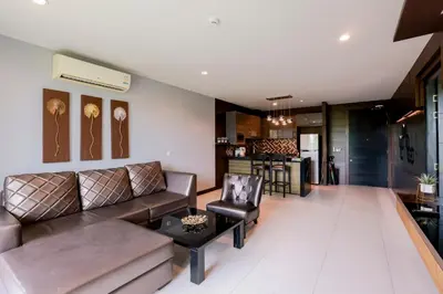 a living room with a couch and a table at The Regent Bangtao Apartments gorgeous view of the jungle in Bang Tao Beach