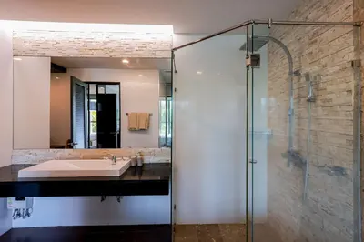 a bathroom with a sink and a glass shower at The Regent Bangtao Apartments gorgeous view of the jungle in Bang Tao Beach