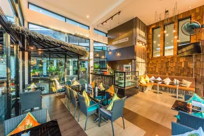 a restaurant with blue chairs and tables and windows at Chalong Miracle Lakeview in Chalong