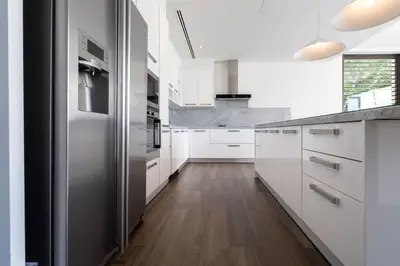 a kitchen with white cabinets and a stainless steel refrigerator at Full Seaview 5BR Villa Serenity, Elite Living at Cape Yamu in Ban Bang La