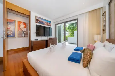 a bedroom with a large white bed with stuffed animals on it at Naithon beachfront apartment-pool gym restaurant in Nai Thon Beach