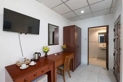 a room with a wooden desk with a television on the wall at Bevans Place Karon in Karon Beach