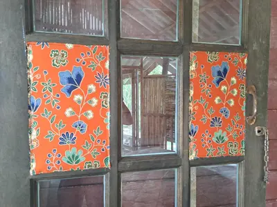 an old door with a window with floral designs on it at Big Hug Home-Nok kao house in Ko Yao Noi