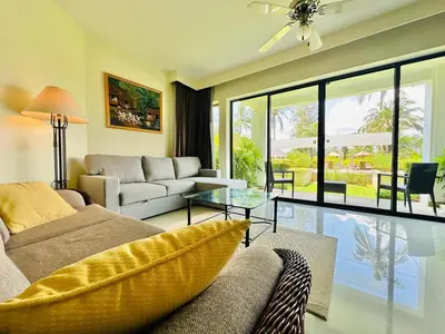 a living room with a couch and a glass table at Golf View, Allamanda 3 Apartment in Ban Mut Dok Khao