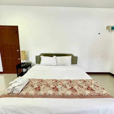 a bedroom with a bed with a rug on it at Chamil House (ชามิล เฮ้าส์) in Ban Ko En