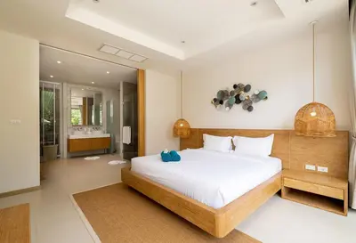 a bedroom with a large bed and a bathroom at 3-Bedroom Pool Villa in Trichada Sky at Bangtao in Bang Tao Beach