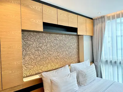a bedroom with a bed with white pillows and a wall at Kamala Beach D723 Exclusive 2 bedroom Suite in Kamala Beach