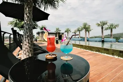 two cocktails sitting on a table next to a pool at Kamala Beach D723 Exclusive 2 bedroom Suite in Kamala Beach