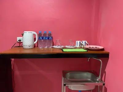 a table with bottles of water on a pink wall at Kanitta Homestay kohyaonoi in Ban Bang Chak